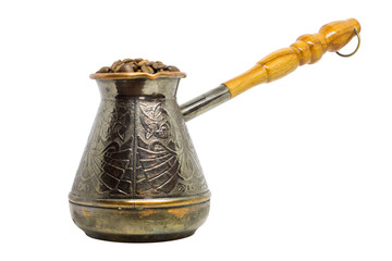 Metal coffee turk with coffee beans isolated on white background.