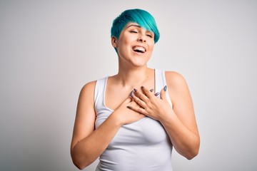 Young beautiful woman with blue fashion hair wearing casual t-shirt over white background smiling with hands on chest with closed eyes and grateful gesture on face. Health concept.