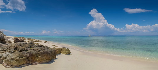 view of arch rock on white sand beach with blue-green sea and blue sky background, Bamboo island, Mu Ko Phi Phi islands, Krabi, southern of Thailand.