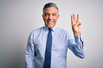 Middle age handsome grey-haired business man wearing elegant shirt and tie showing and pointing up with fingers number three while smiling confident and happy.