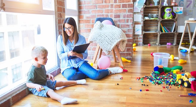 Young therapist woman speaking with child, counselor and behaviour correction at the office around toys