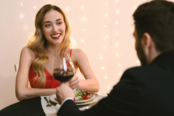 Happy Couple Clinking Red Wine Glasses On Romantic Dinner In Restaurant