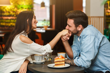 Loving Boyfriend Kissing Girlfriend's Hand Having Date In Cafe