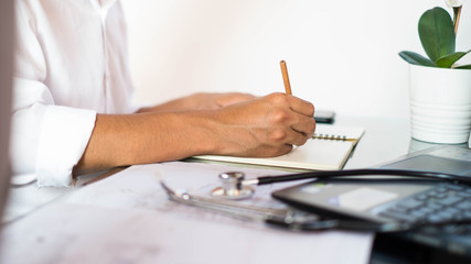 The doctor recorded the patient's treatment in a notebook.Vaccination concept. laboratory, medical...