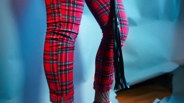 Close-up of a girl standing in high heels at a kinky party.