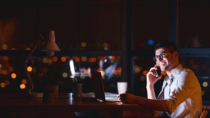 Entrepreneur Talking On Cellphone Sitting In Modern Office, Panorama