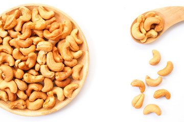 border and frame of cashew nuts in wooden dish isolated on white background with copy space.