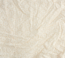 texture of crumpled beige synthetic fabric guipure for sewing clothes