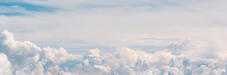 Banner 3:1. Blue sky with fluffy clouds. Aerial view from airplane window