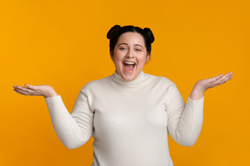 Surprised Plus Size Girl Posing With Spreaded Hands Over Yellow Background