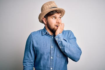 Young handsome blond man with beard and blue eyes wearing denim shirt and summer hat looking stressed and nervous with hands on mouth biting nails. Anxiety problem.