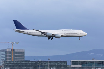 Landing an airplane at a major airport amid urban buildings.