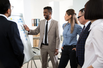 Group of mixed business people having a meeting using a white board in an office