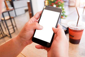 Mockup picture of business man’s hands holding smart phone with white blank screen in modern place.