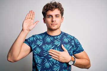 Young blond handsome man on vacation with curly hair wearing casual summer t-shirt Swearing with...