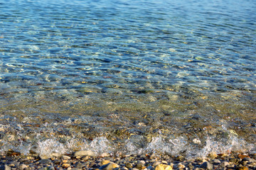 Waves with foam blue  sea on a sunny sandy beach in resort on summer vacation rest.