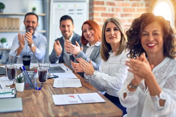 Group of business workers smiling happy and confident. Working together with smile on face looking at the camera applauding at the office