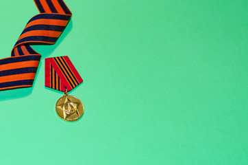 Happy Victory Day! St. George ribbon  and medal on a green background. The 75th anniversary of the victory in the Great Patriotic War.