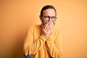 Middle age hoary man wearing casual sweater and glasses over isolated yellow background laughing...