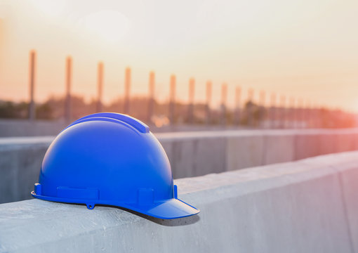 blue hard safety helmet hat for safety project of workman as engineer or worker, on concrete floor on construction site background.