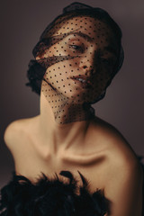 fashion portrait of beauty elegant girl posing in black veil on dark background. gorgeous stylish...