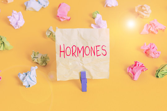 Writing note showing Hormones. Business concept for regulatory substance produced in organism transported tissue fluids Colored crumpled paper empty reminder white floor clothespin