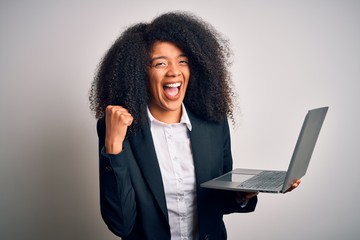 Young african american business woman with afro hair using computer laptop from job screaming proud...