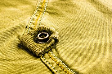 clothing items stonewashed cotton fabric texture with seams, clasps, buttons and rivets, macro