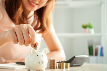 Women are putting coins in a piggy bank for a business that grows for profit and saving money for the future. planning for retirement concept