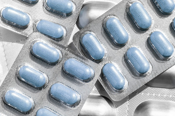 Several of blisters with colored blue tablets of different shapes close-up