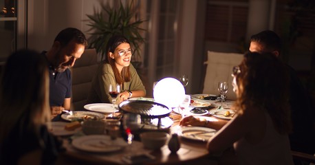 Beautiful family on dinner talking and smiling at terrace