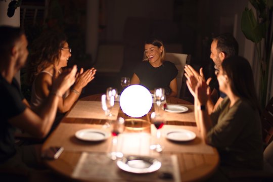 Beautiful family on dinner applauding and smiling at terrace