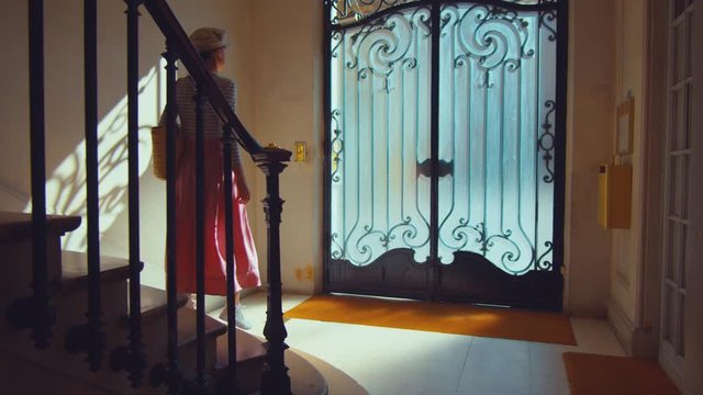 Young woman coming out of a vintage door in the porch, Paris