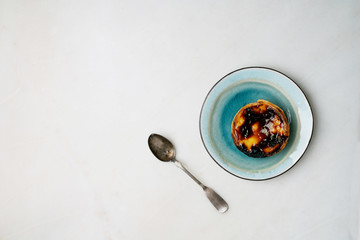  Pastel de nata. Traditional Portuguese dessert, egg tart on the ceramic plate with spoon over marble background. Top view