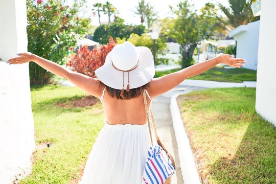 Young beautiful woman on white houses village walking on the streets on a sunny day of summer