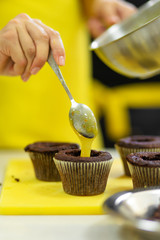 The process of making chocolate cupcakes with sweet cream. Creation of cakes by professional pastry chefs