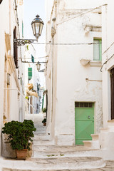 Fototapeta na wymiar white houses, small alley with stairs in Ostuni, Italy
