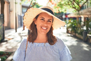 Young beautiful woman smiling happy walking on city streets on a sunny day of summer