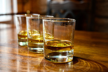 Flight of Scottish whisky, tasting glasses with variety of single malts or blended whiskey spirits on distillery tour in pub in Scotland