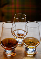 Flight of Scottish whisky, tasting glasses with variety of single malts or blended whiskey spirits on distillery tour in Scotland