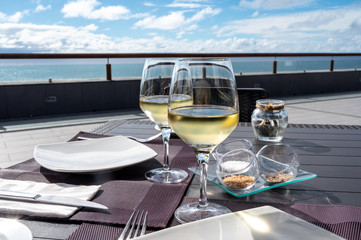 Cold white wine served in restaurant with ocean view