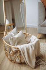 Fototapeta na wymiar grey white pillow and blanket in wood basket on cozy white bright interior