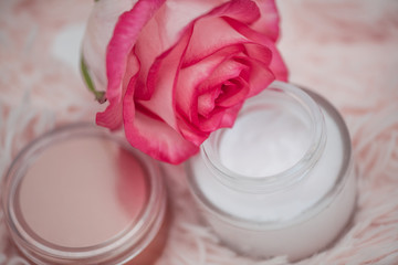 Skincare concept. cream in a glass jar with an open lid and a rose