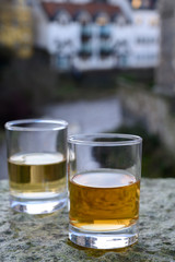 Scotch single malts or blended whisky spirits in glasses with old houses of Edinburgh on background, Scotland, UK