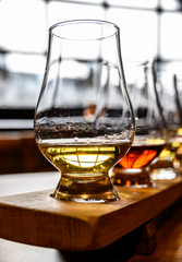 Flight of Scottish whisky, tasting glasses with variety of single malts or blended whiskey spirits on distillery tour in Scotland