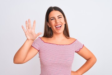 Portrait of beautiful young woman standing over isolated white background showing and pointing up with fingers number five while smiling confident and happy.