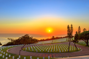 Cemetery graveyard white tombstones at sunset sky. American war cemetery in Point Loma, San Diego,...