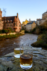 Scotch single malts or blended whisky spirits in glasses with old houses of Edinburgh on background, Scotland, UK