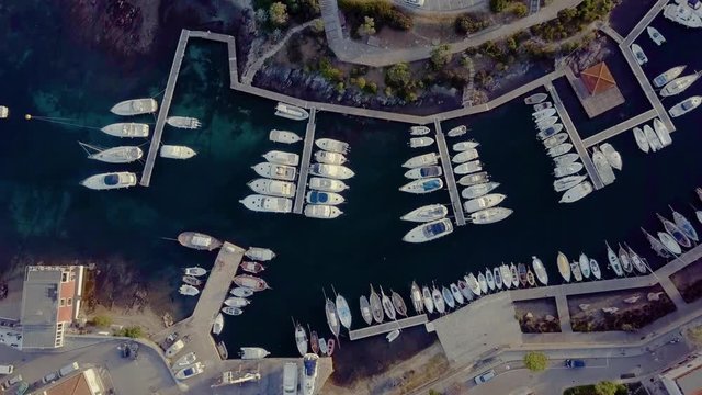 Aerial of a pretty village in Sardinia, Italy. Sunrise on the coast, parking yachts, mountains in the background
