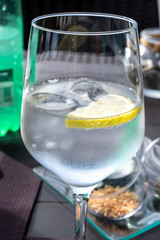 Cold mineral water with bubbles in glass with lemon